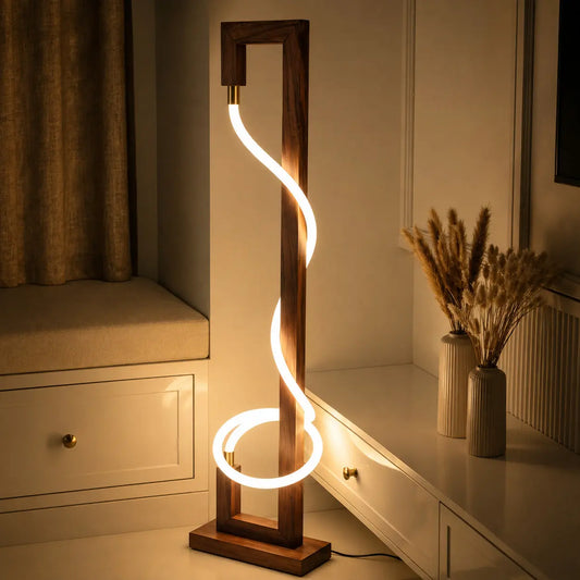 Rosewood spiral floor lamp glowing warm at night beside white cabinets and pampas grass vases