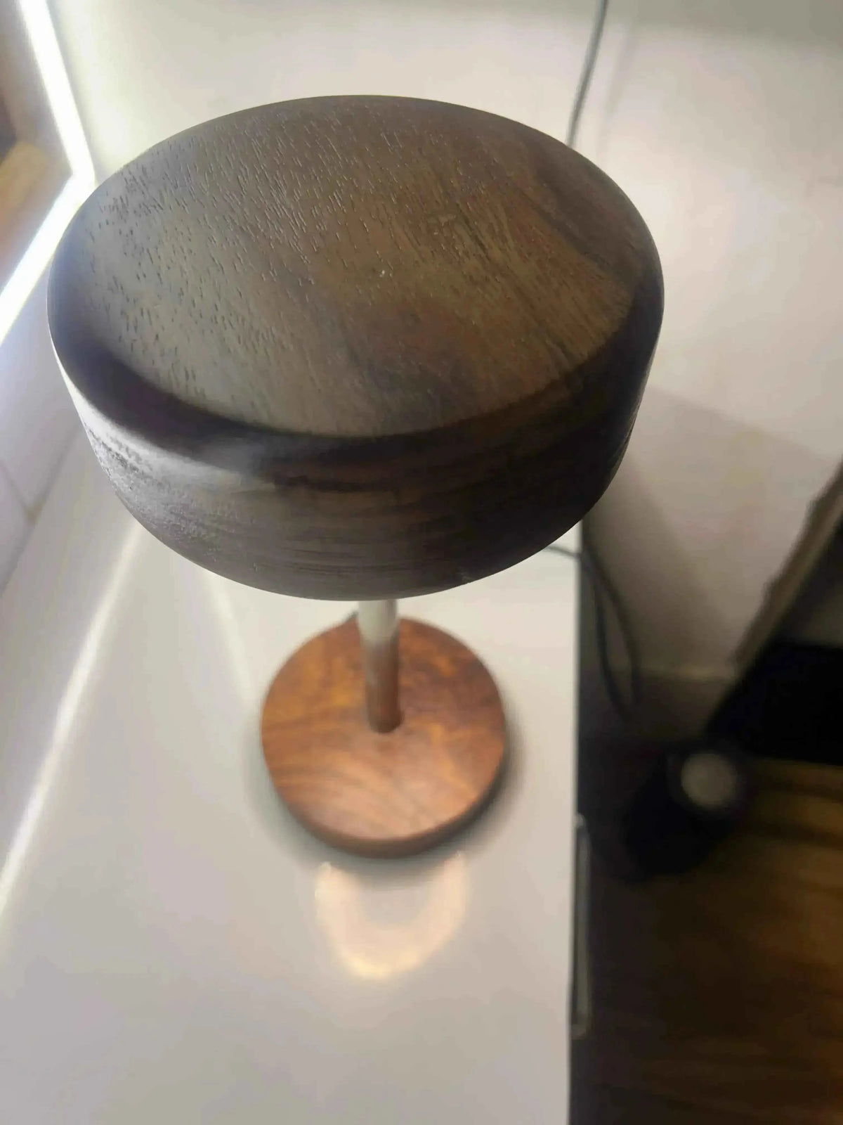 Top-down close-up of the rosewood shade grain and round base on this LED table lamp