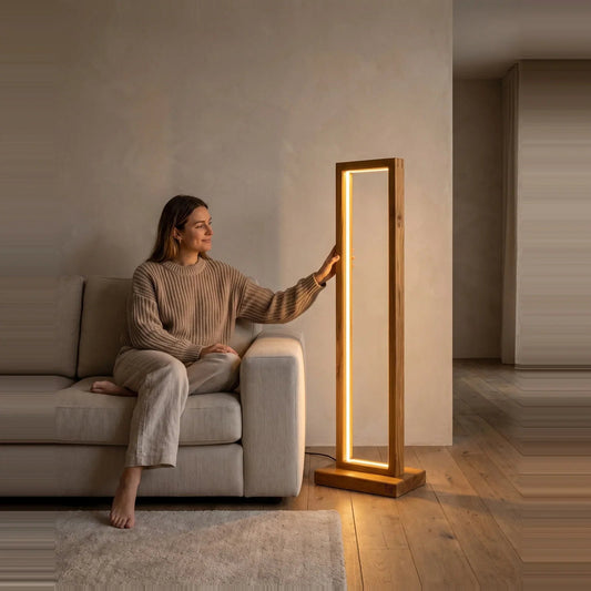 Woman seated on a sofa beside the Tall Teak Wood Floor Lamp, showing its 40 inch height against a person