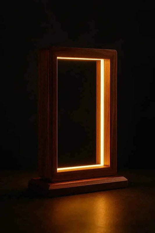 Rosewood frame table lamp lit in total darkness, LED ring glowing inside the open frame