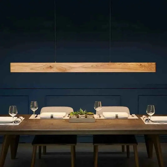 Pine wood linear pendant light front view over a set dining table against a navy wall