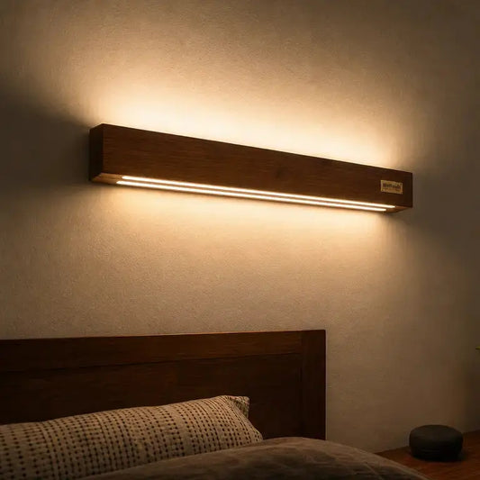 Sheesham wood up-down wall light mounted above a bed headboard in a warm bedroom