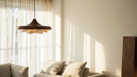 minimalist living room with wooden pendant lamp and warm sunlight highlighting natural textures