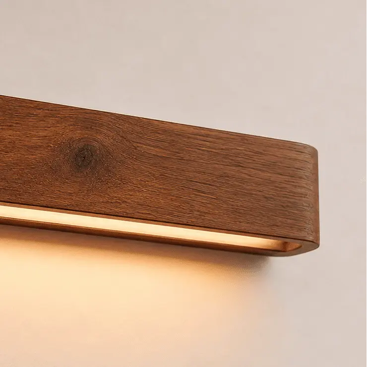 Aure wooden wall light close up, showing wood grain and the warm LED beneath