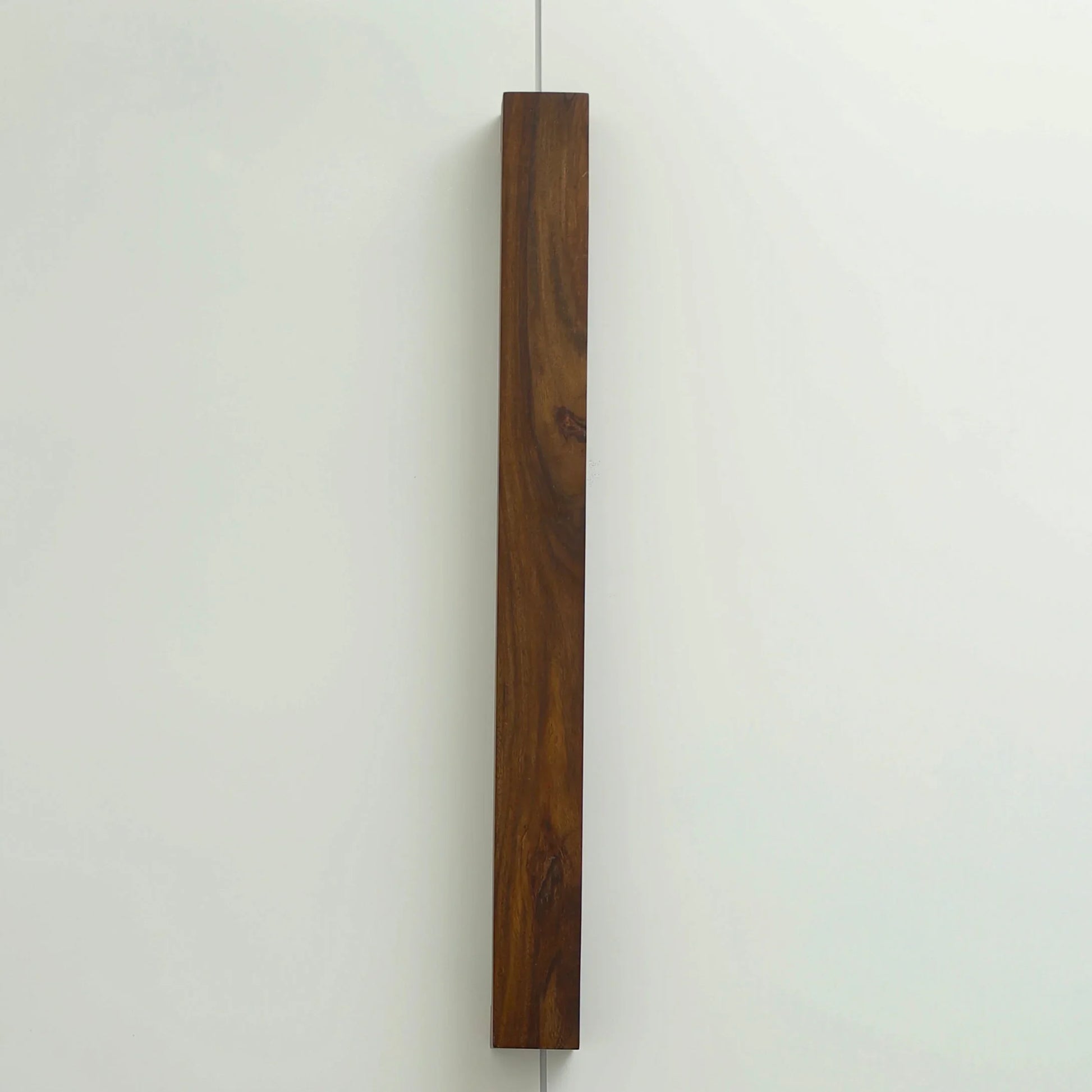 Nix Line vertical wall light in dark solid wood on a pale wall - NixWoods handcrafted wall sconce