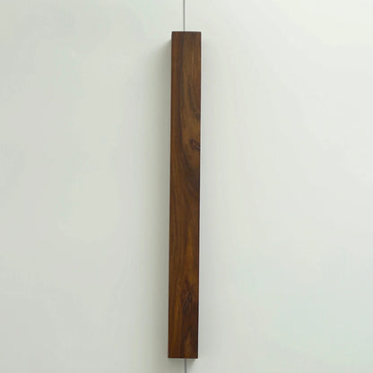 Nix Line vertical wall light in dark solid wood on a pale wall - NixWoods handcrafted wall sconce