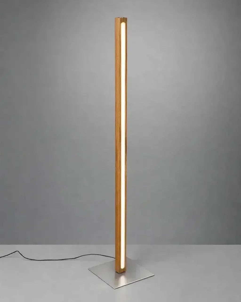 Scandinavian Teak Linear Floor Lamp against a grey studio wall, warm LED running the full height of the solid teak column