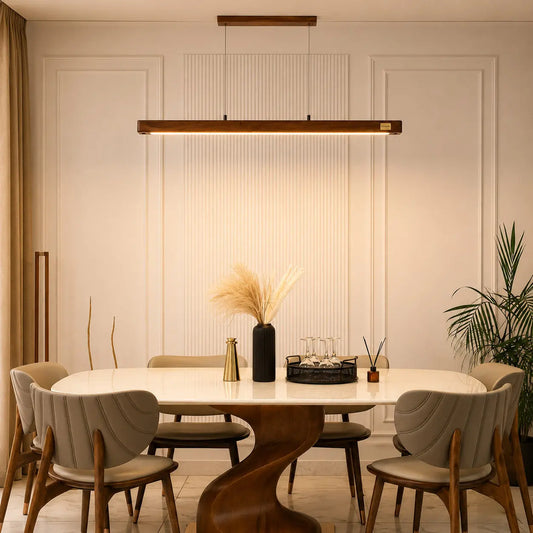 Ambient Light Fixture wooden linear pendant front view above a dining table with pampas grass
