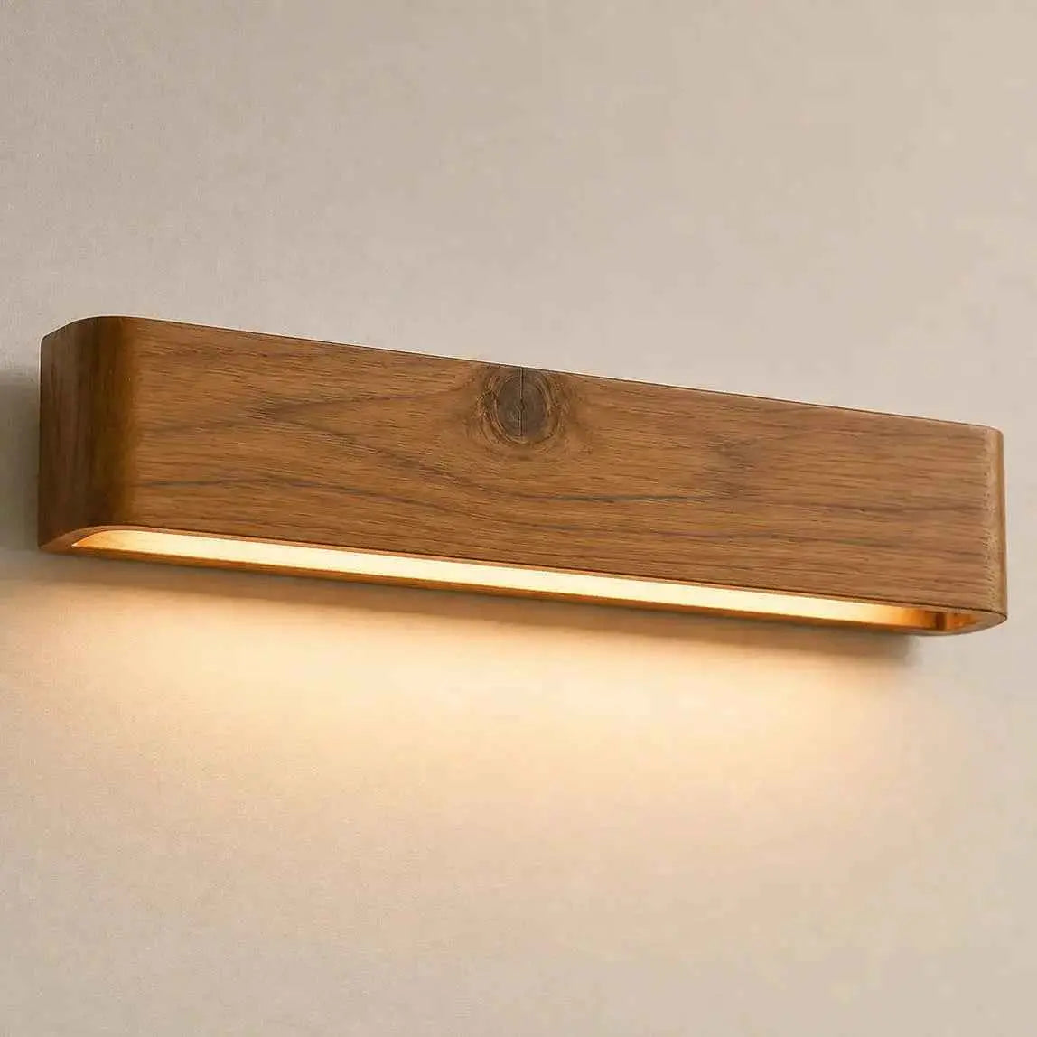 Aure teak wood linear LED wall light sconce glowing warm on a wall — NixWoods