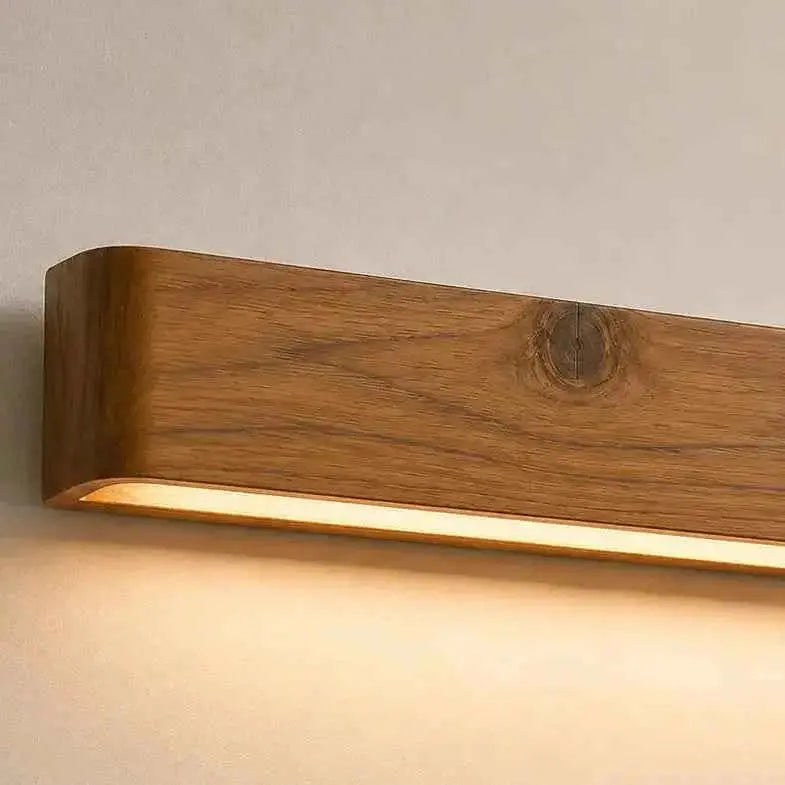 Aure solid teak linear LED wall light close-up showing the grain and a knot, NixWoods