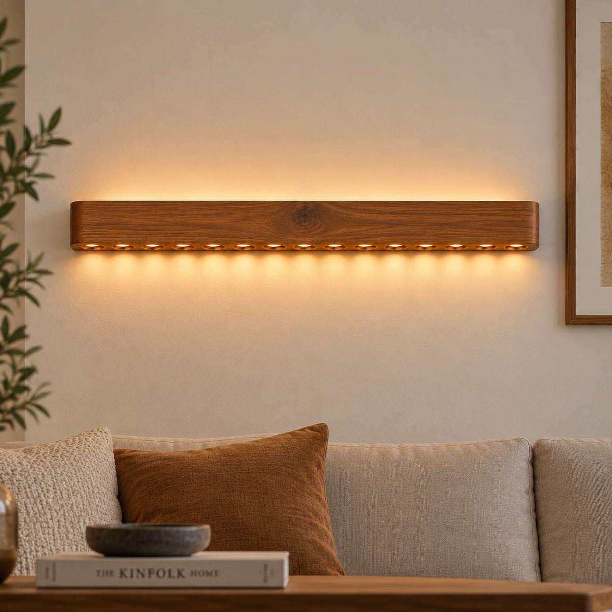 24-inch wooden wall light casting a row of warm light dots above a sofa with rust and cream cushions