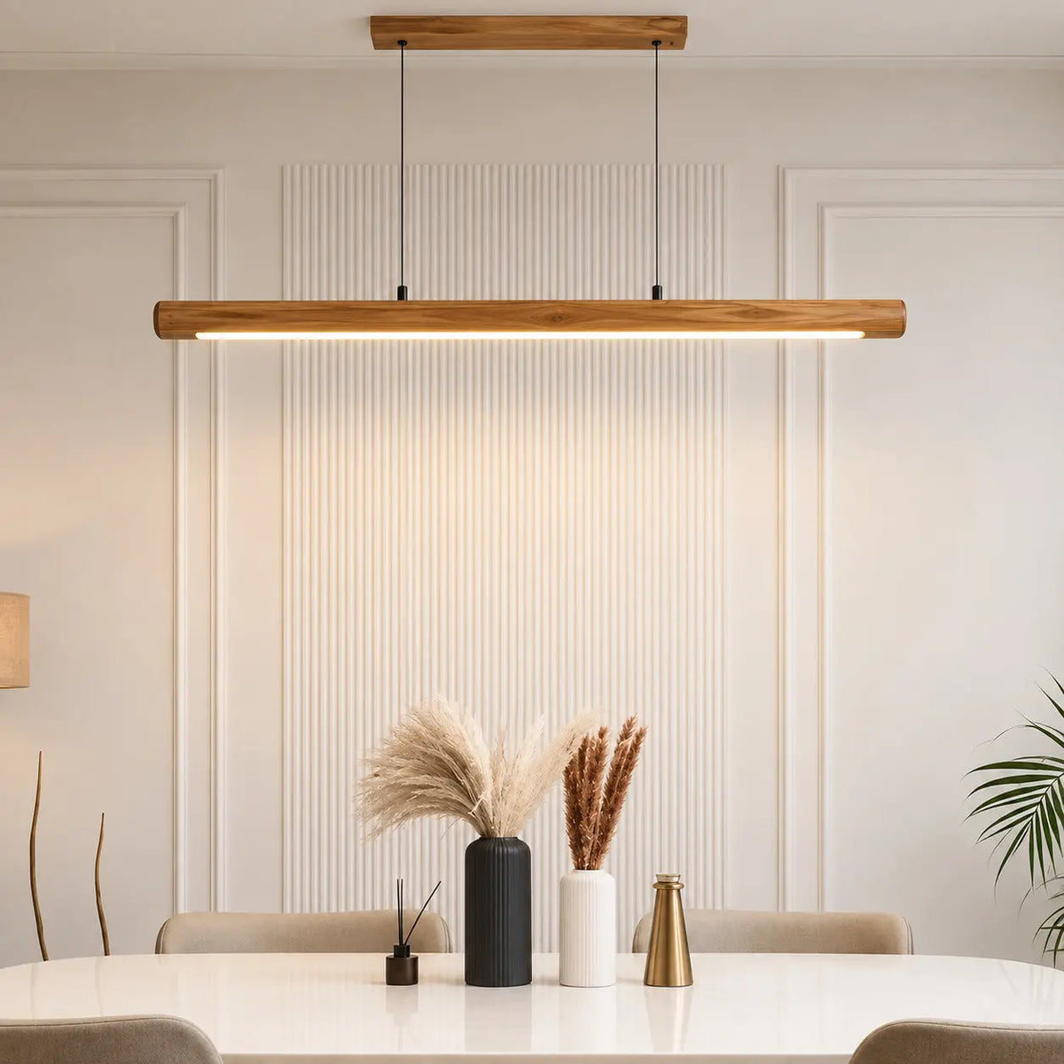 Rosewood linear pendant light glowing above a dining table with pampas grass and a brass vase — NixWoods