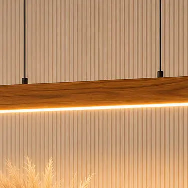 Warm white LED strip under the teak bar glowing onto a fluted wall panel