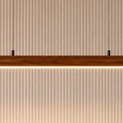 Close-up of the rosewood pendant's warm LED strip underside against a fluted white panel