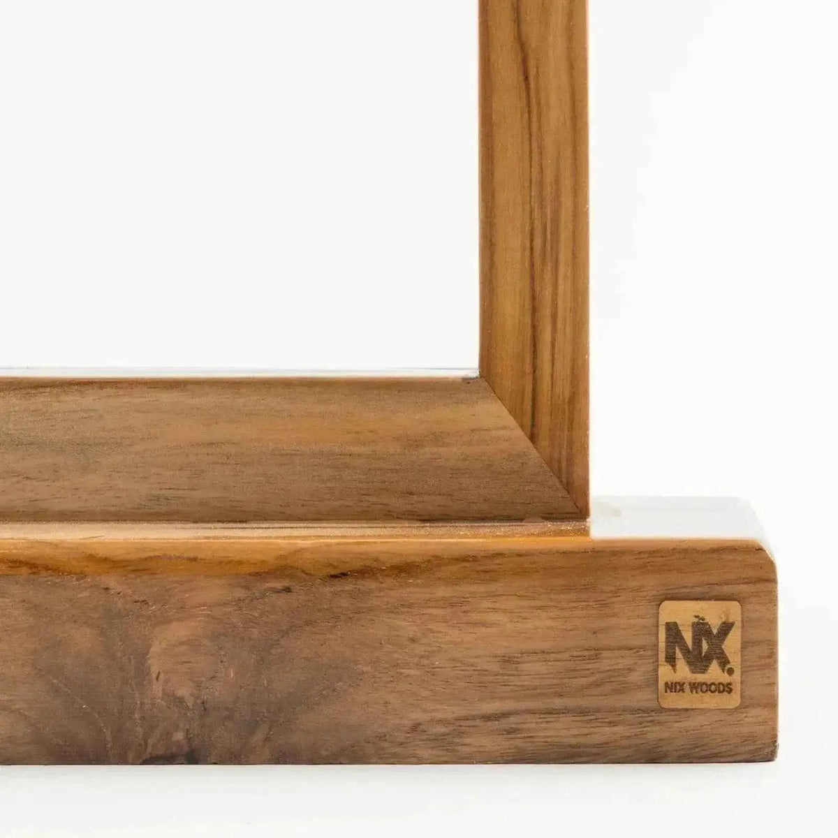 Close-up of teak grain on the lamp base with the engraved NX Nix Woods badge