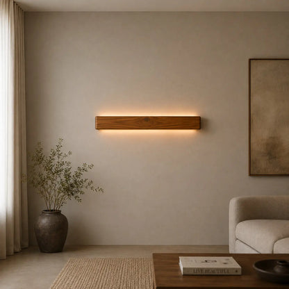 Teak wood wall light glowing warm white over a living-room seating corner