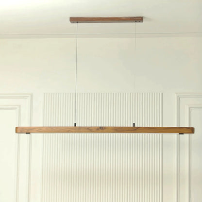 Teak wood pendant bar shown against a fluted white wall - NixWoods linear hanging light