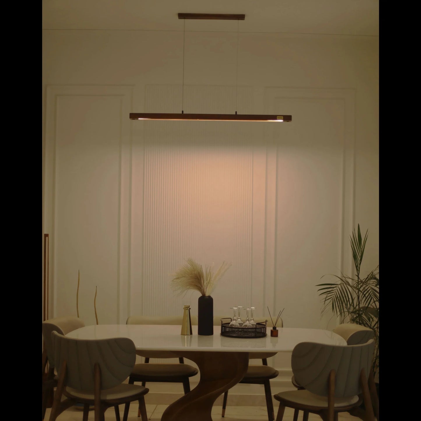 Warm-lit wooden pendant light over a dining table at night - NixWoods hanging ceiling light