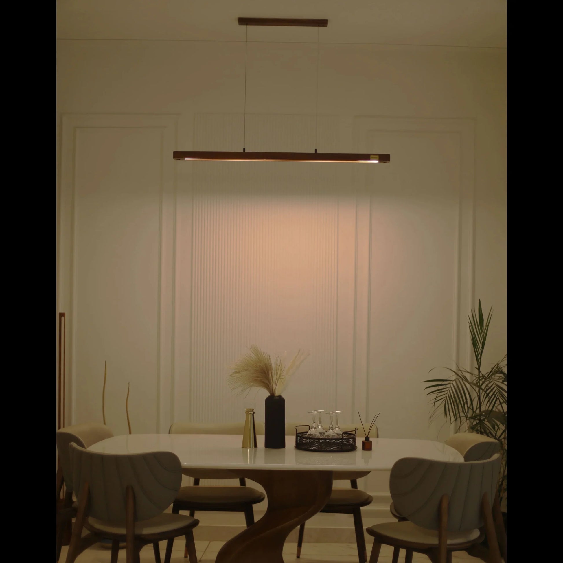 Warm-lit wooden pendant light over a dining table at night - NixWoods hanging ceiling light