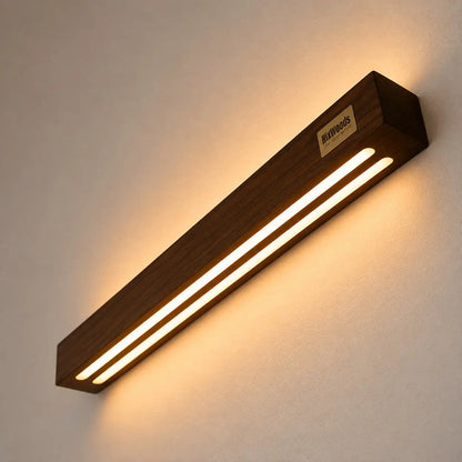 Angled close-up of the sheesham wall light with two warm LED strips and brass plaque