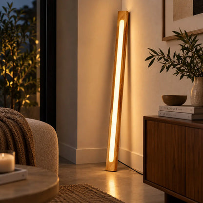 NixLine solid teak floor lamp leaning in a living-room corner beside an armchair