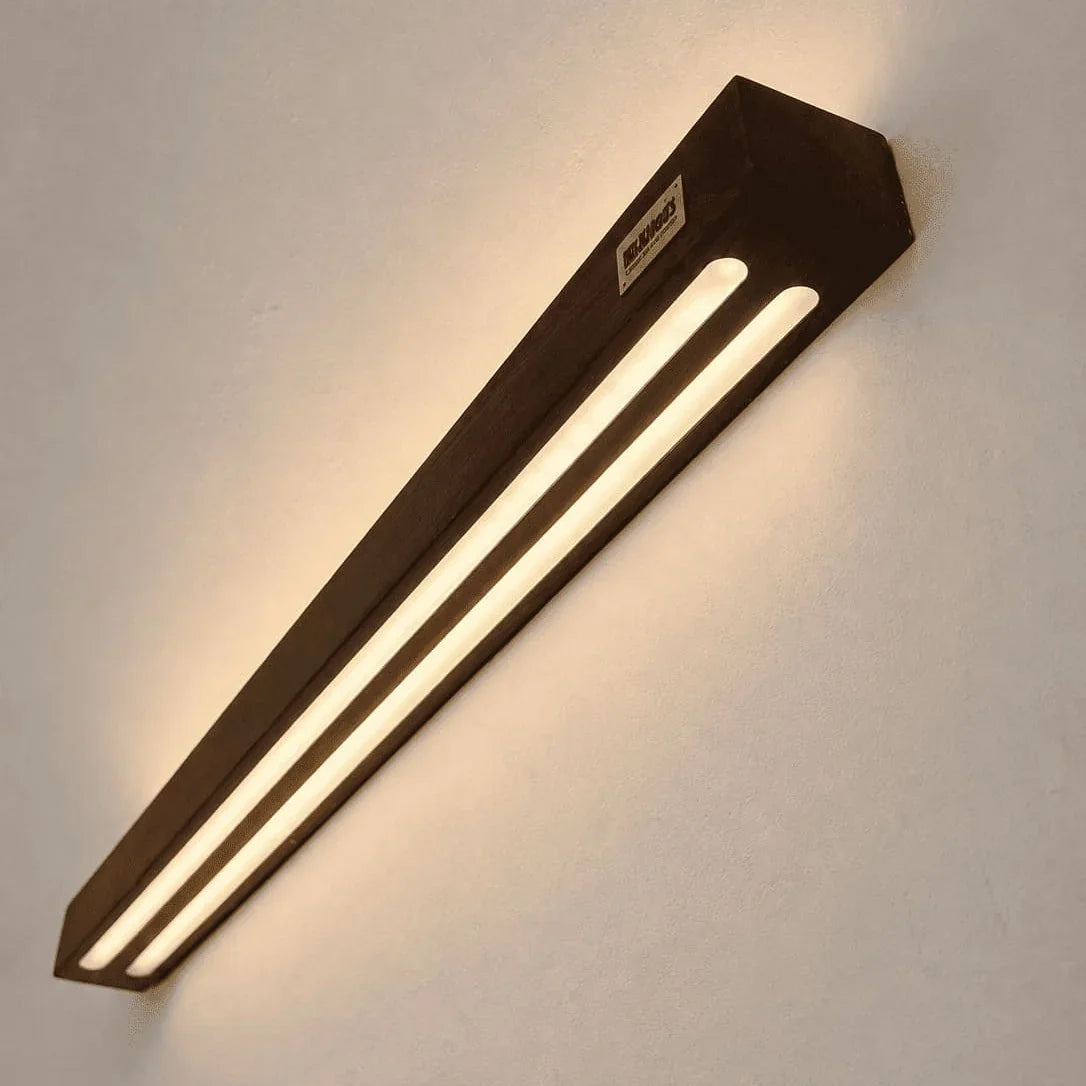 Angled view of the Sheesham rosewood wall lamp lit by twin warm LED strips - NixWoods wall sconce