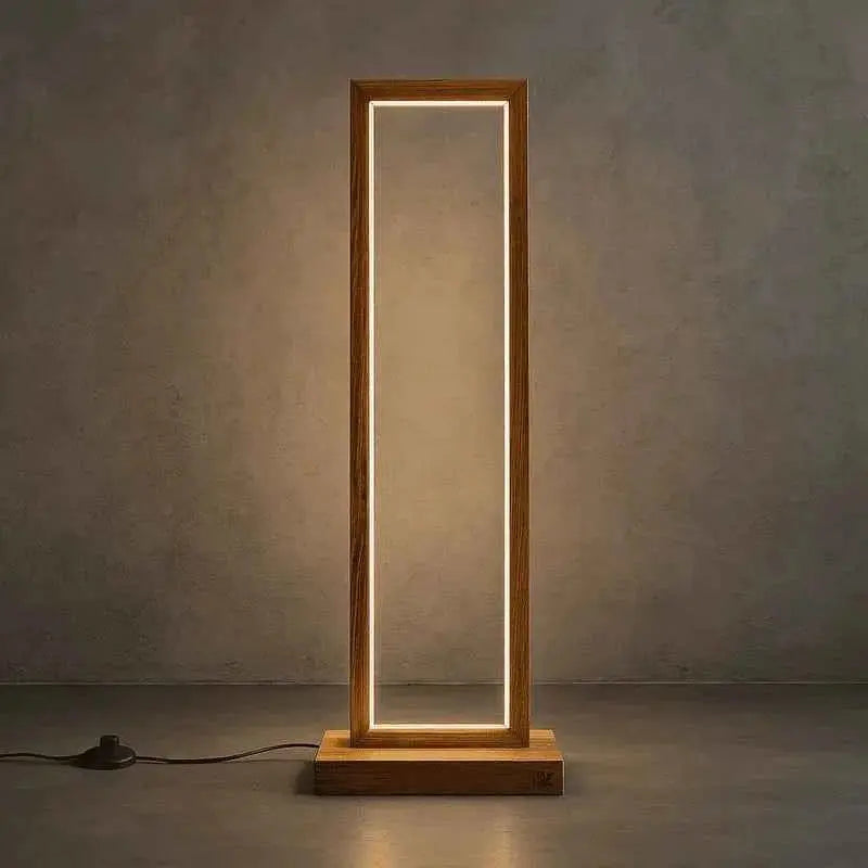 Tall Teak Wood Floor Lamp with warm LED lining its rectangular frame against a concrete wall