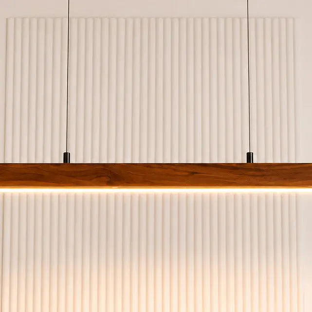 Close-up of the warm white LED strip under the wooden bar lighting a fluted wall