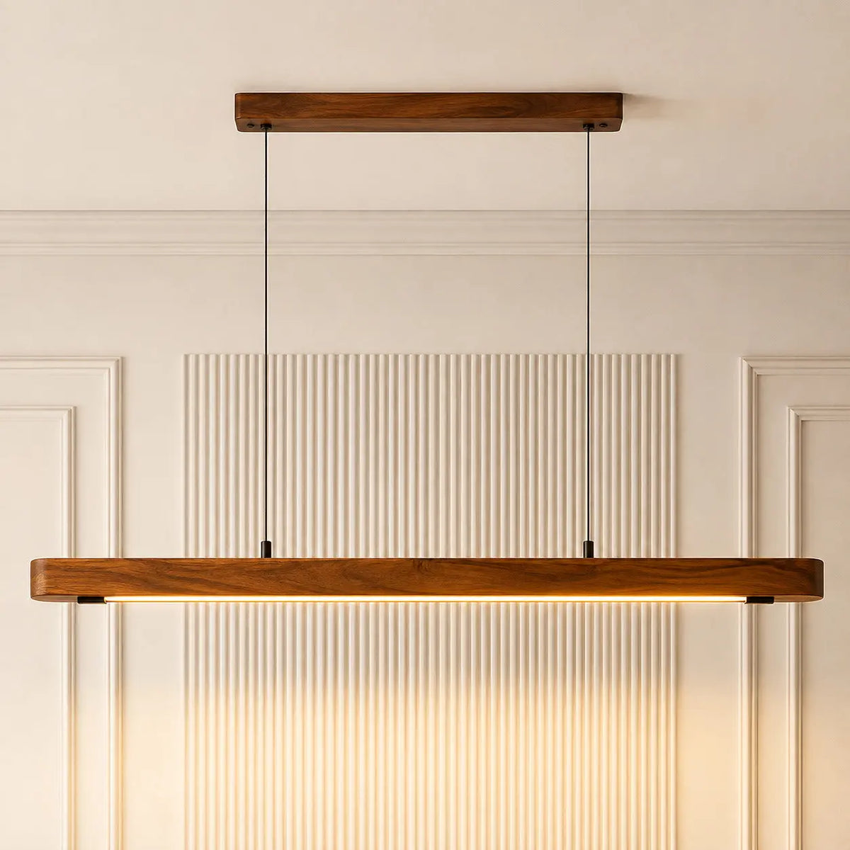 Teak linear pendant seen straight on, twin black cables and ceiling canopy against a fluted wall