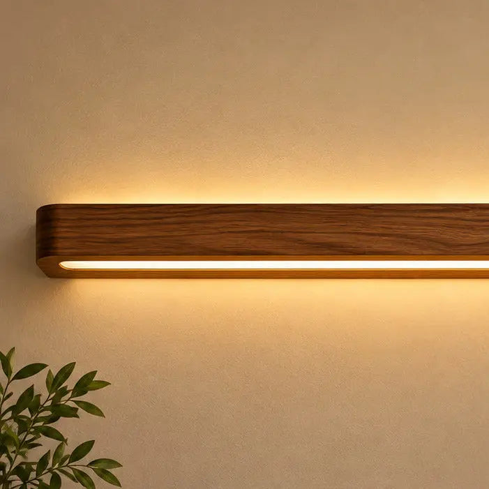 Close-up of dark teak grain and the continuous warm LED strip running the length of the wall light