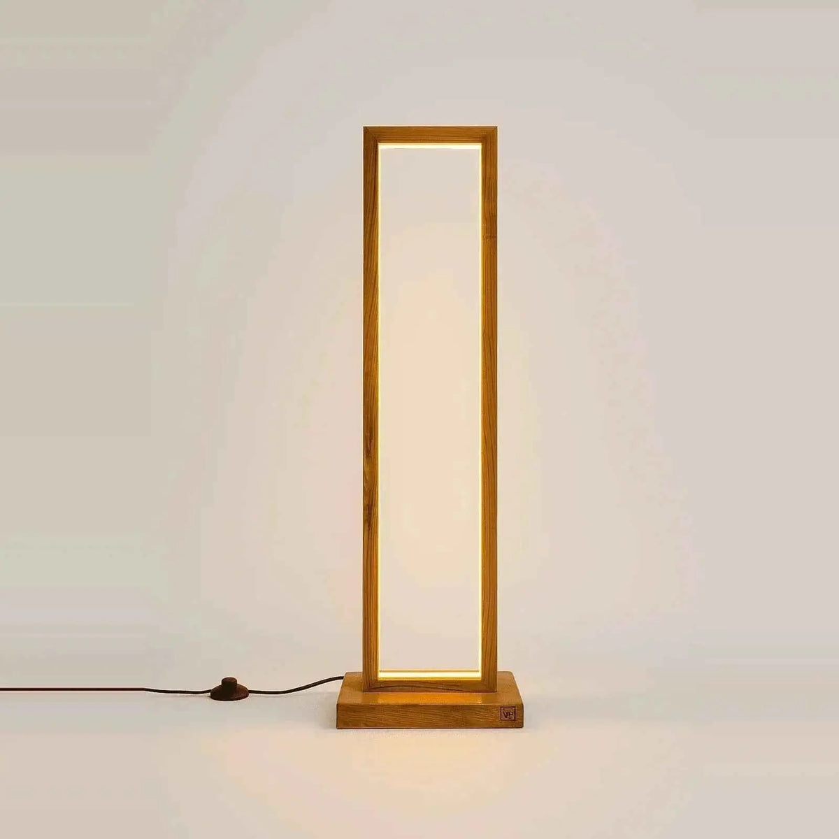 Front view of the teak rectangular floor lamp on white with its cord and foot switch