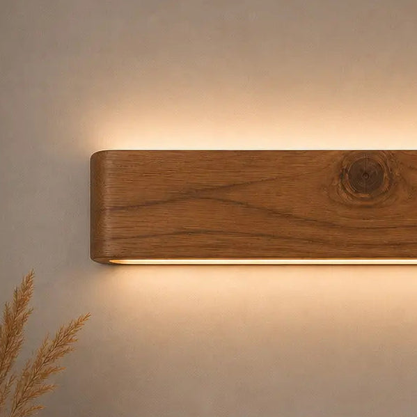 Close-up of rosewood grain on the Arden wall light with a warm downward LED wash