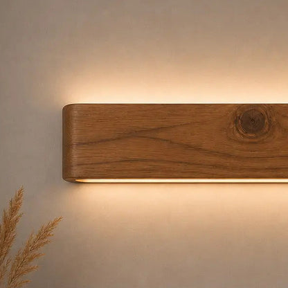 Close-up of rosewood grain on the Arden wall light with a warm downward LED wash