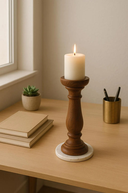 Candle in a wooden holder on a table with books and a plant in the background