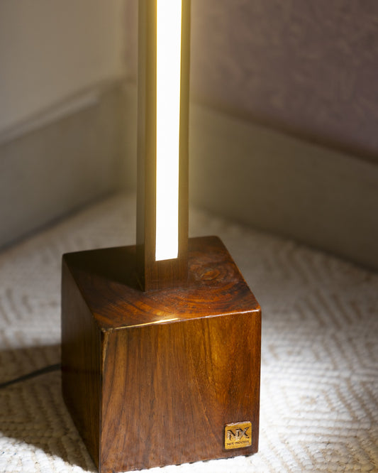 Close up of the NixWoods floor lamp base - solid rosewood cube with visible grain and the burned-in NIX WOODS badge