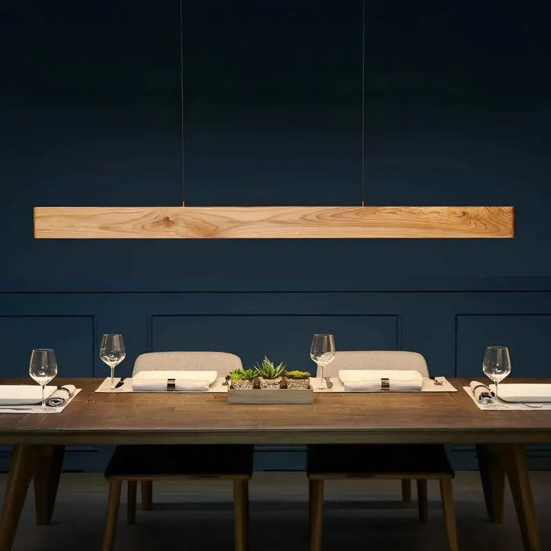 Pine wood linear pendant light above a set dining table - NixWoods handcrafted hanging light