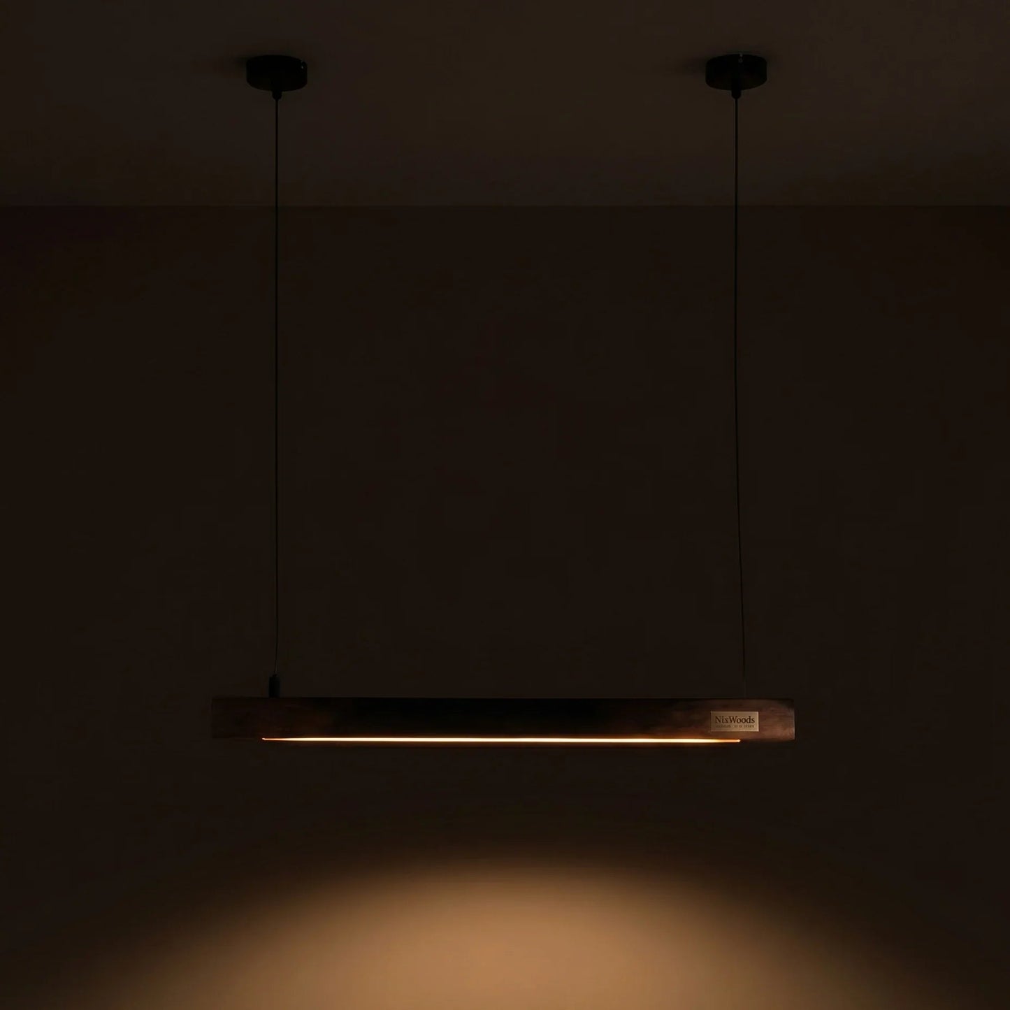 Handcrafted rosewood Scandinavian linear pendant light glowing warm amber — NixWoods